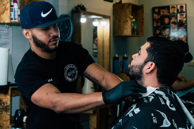A skilled barber at Catch a Fade Barbershop near Philadelphia carefully shaping a client's beard with a straight razor. Book your appointment online for expert men's grooming services.